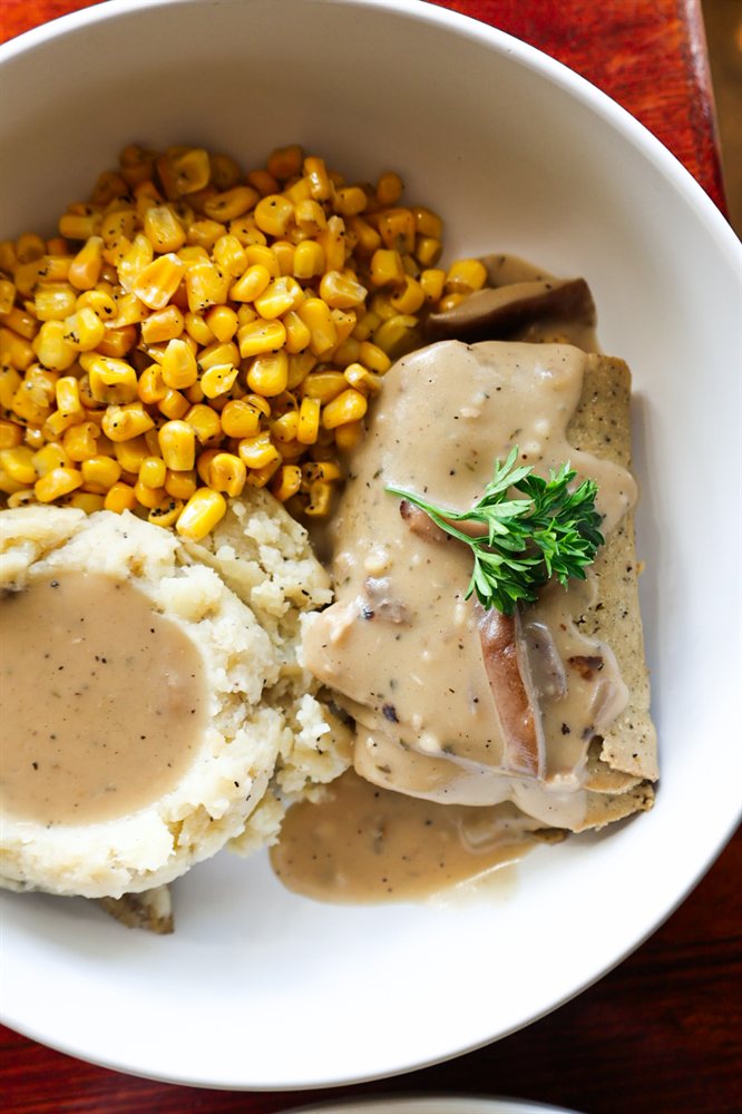 Thanksgiving bowl with seitan "turkey" slices, mashed potatoes, corn, and herbed gravy